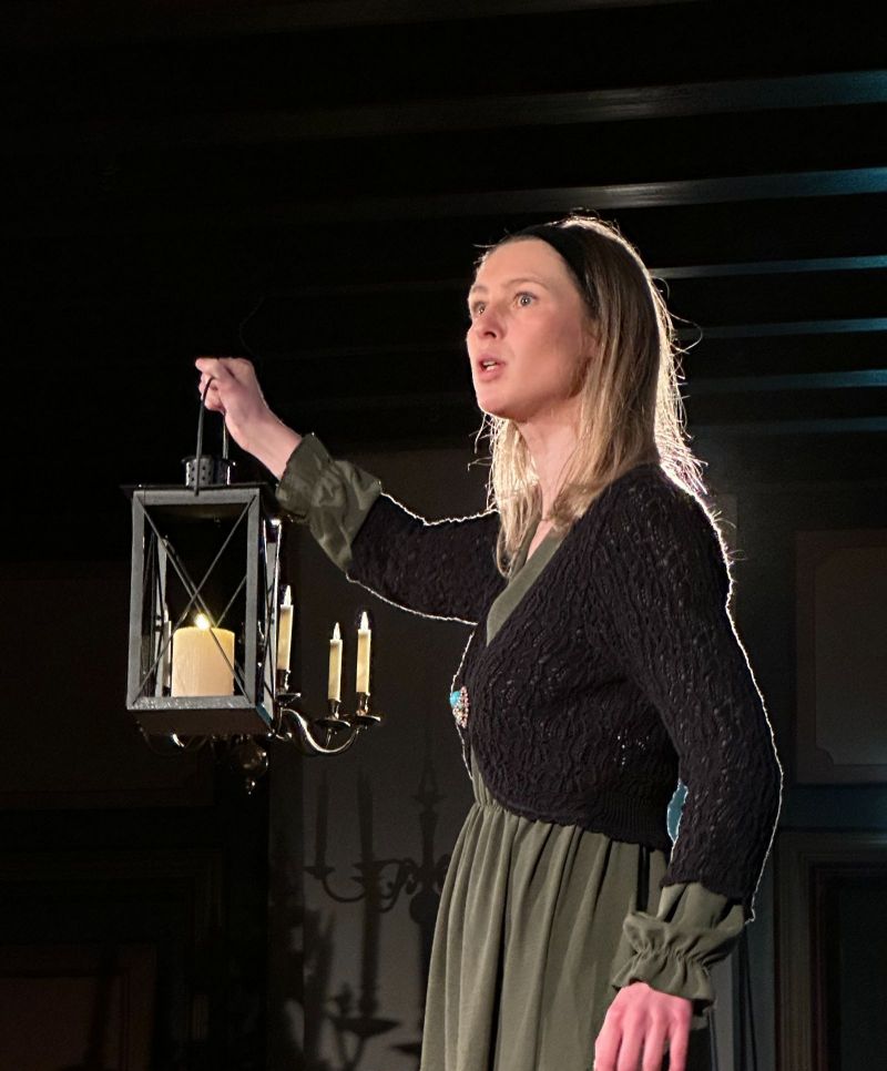 Lady on stage holding a candle light