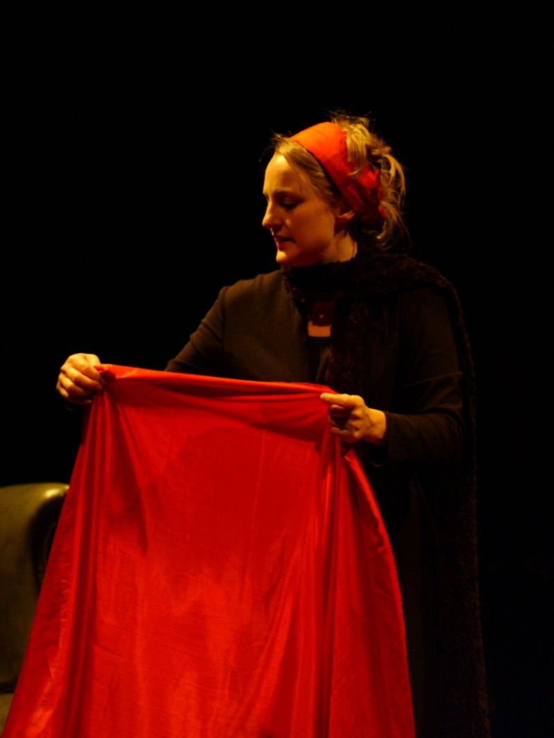 Kristina is sitting working a long piece of red satin suggesting that she is mending a dress (for Nora).