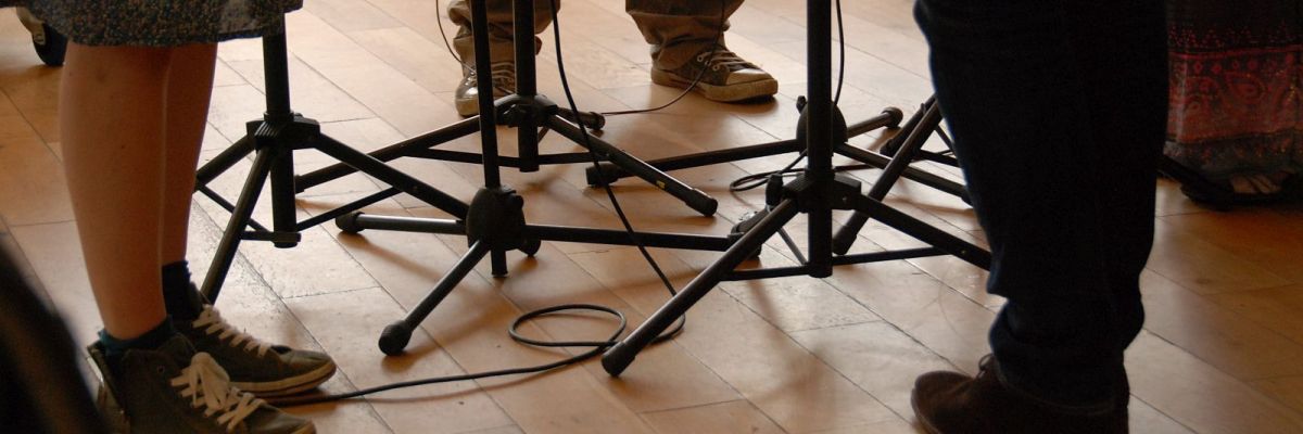 An image of several feet gathering around a number of music stands.